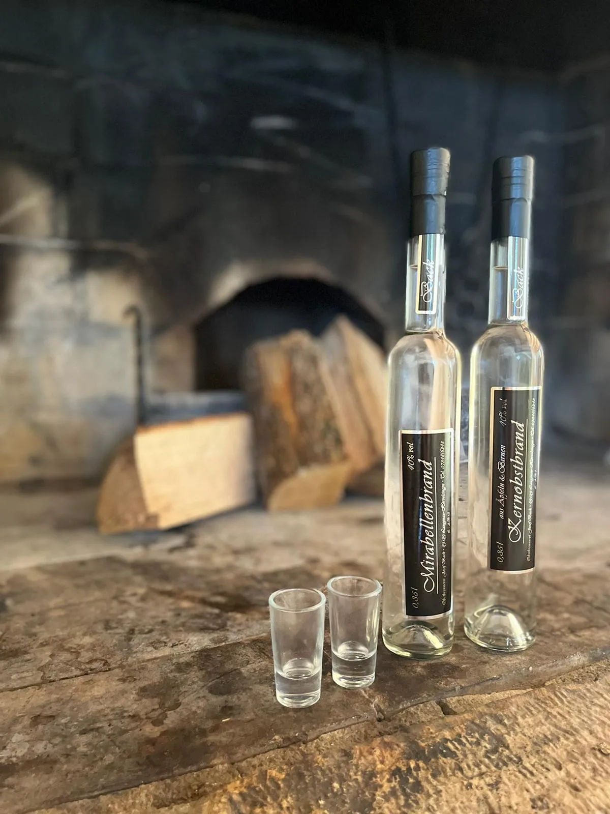 Zwei Flaschen und Schnapsgläser auf einem Holztisch