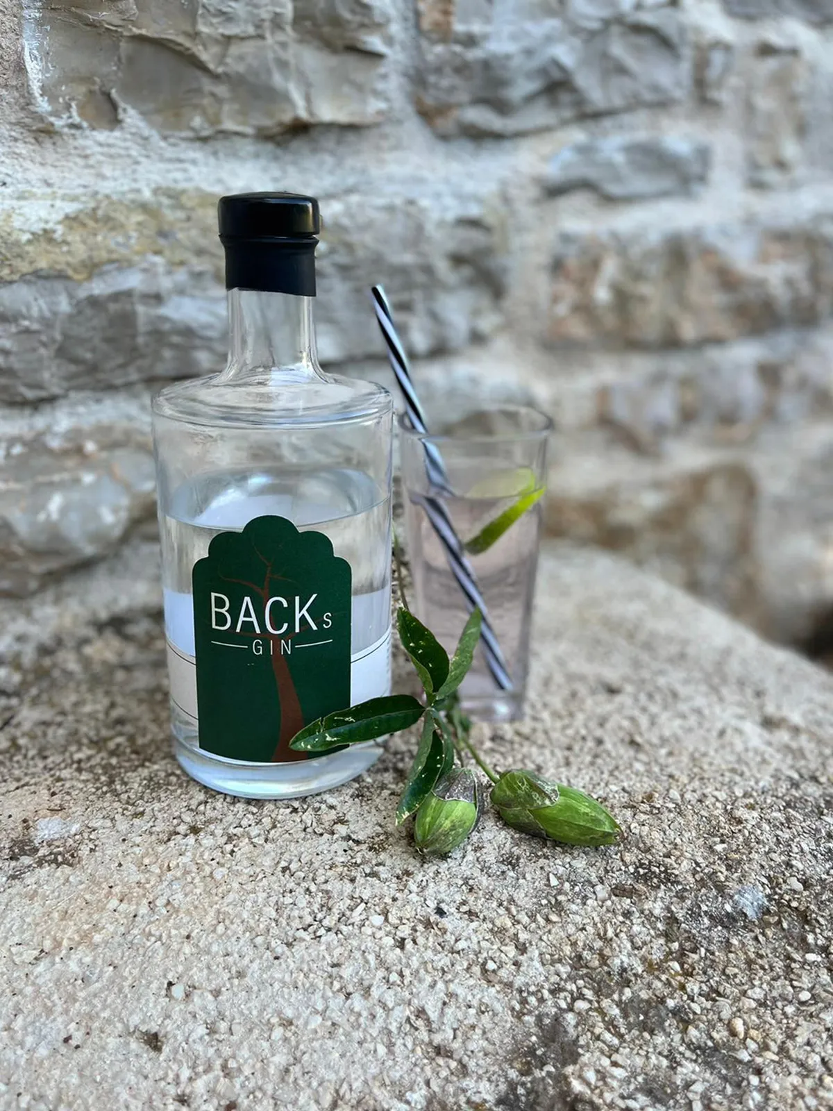Eine Flasche "Backs Gin" neben einem vollen Glas